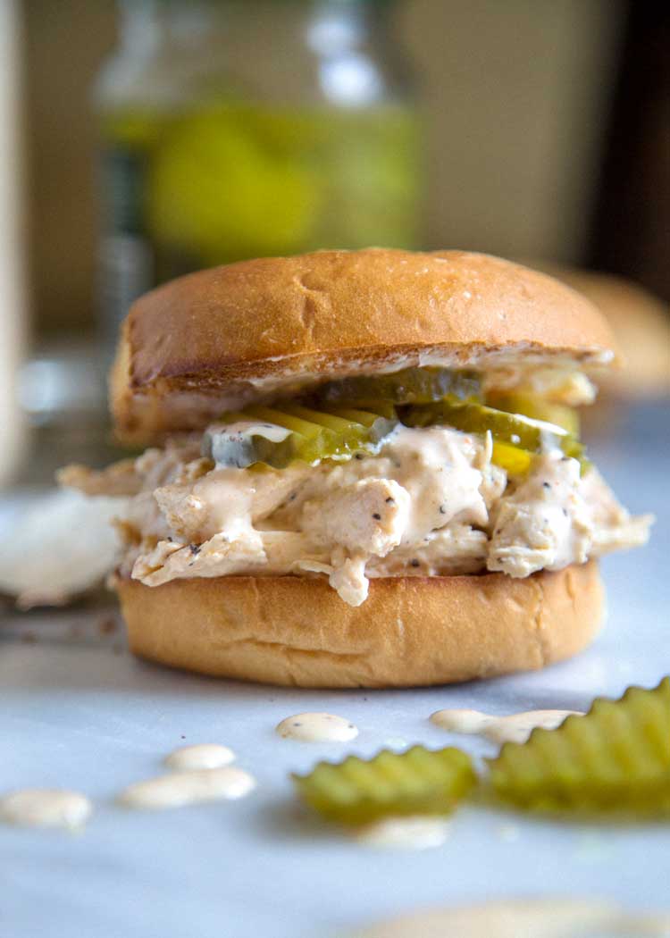 close up of a shredded chicken sandwich with pickles