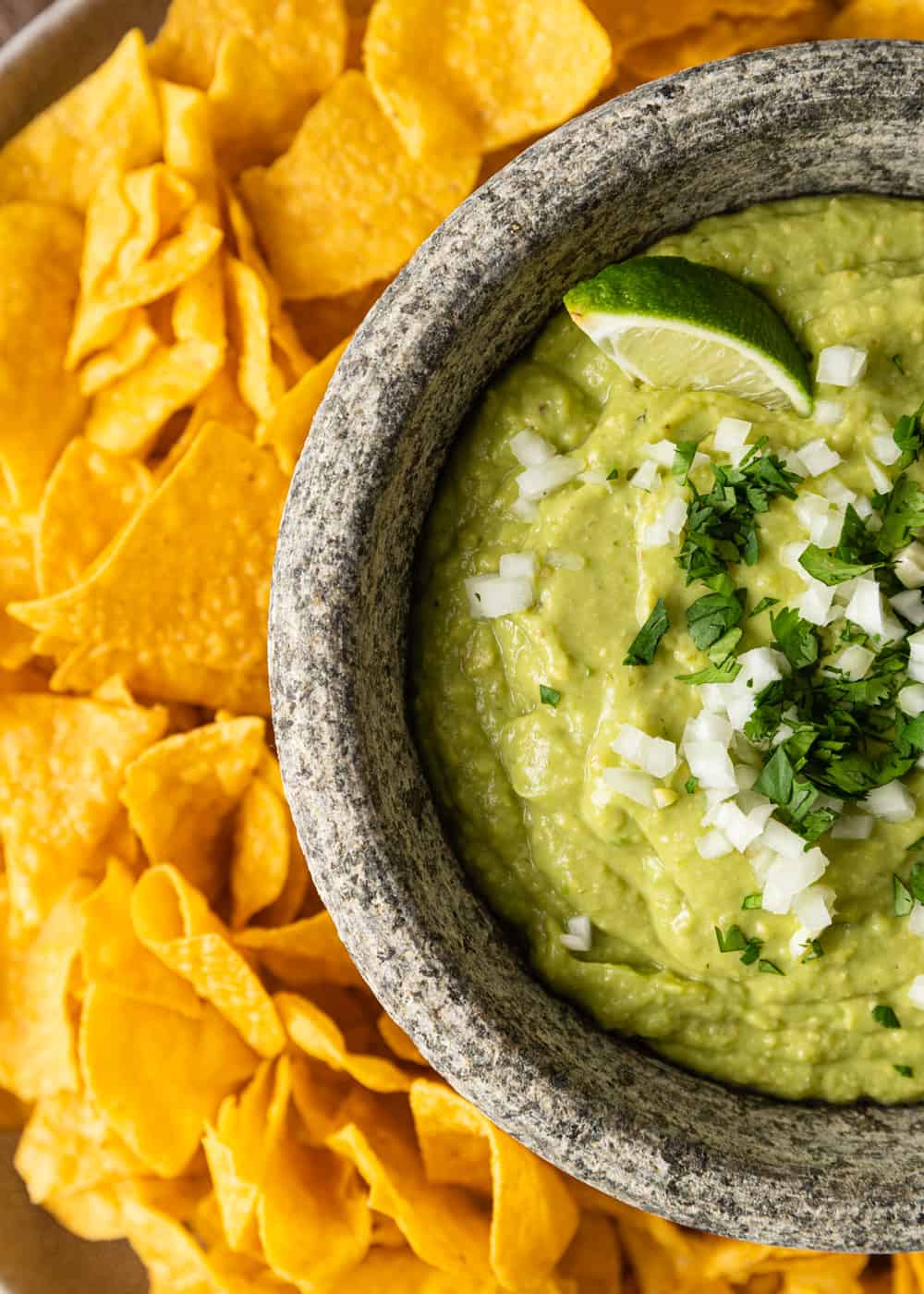 overhead shot of thick creamy green mexican dip in stone bowl