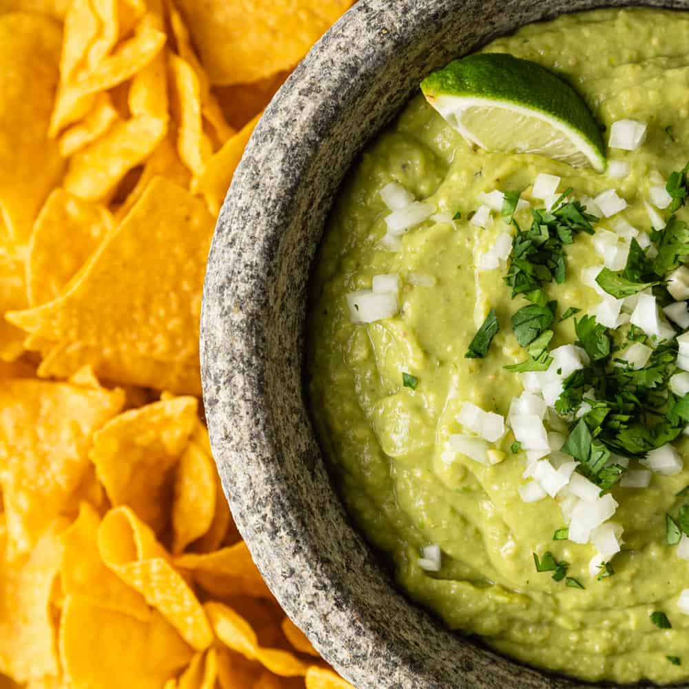 bowl of guacamole salsa and tortilla chips