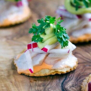 These crispy, hand held Baja Yellowtail Tostadas are made with fresh fish tossed in lime juice, a spicy sauce, radishes, avocado mousse and cilantro. www.keviniscooking.com