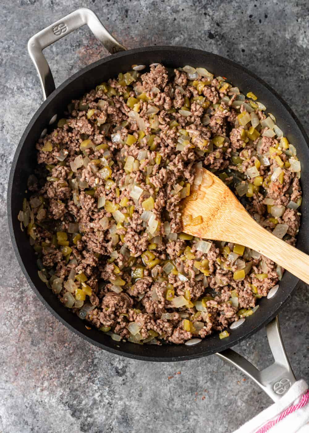 overhead: browning ground beef onions and peppers in skillet