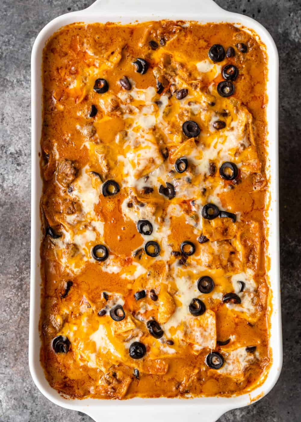 pan of enchiladas covered with cheese and black olives