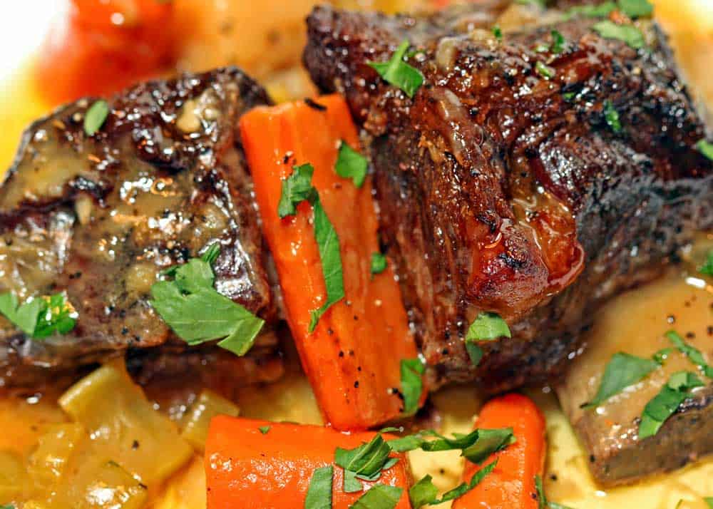 a close up look at braised beef short ribs and carrots
