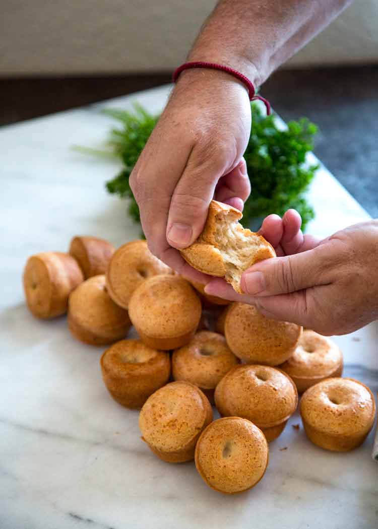 tearing Brazilian cheese bread apart with two hands