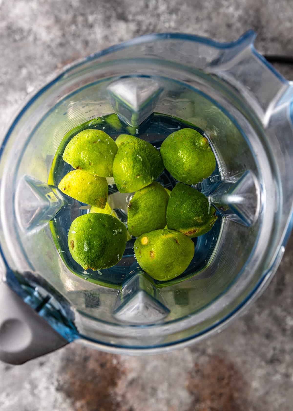 overhead: lime wedges in a blender with water