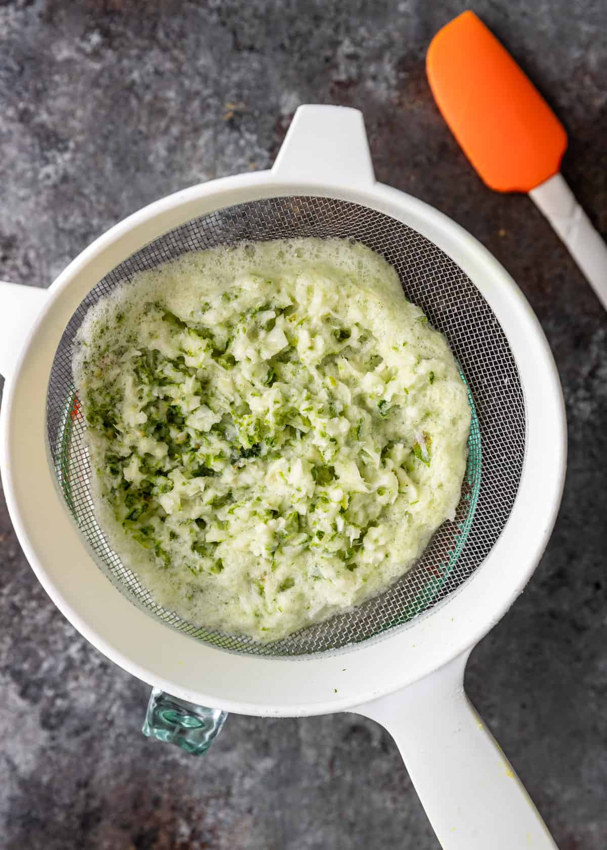 overhead: straining blitzed limes in a colander