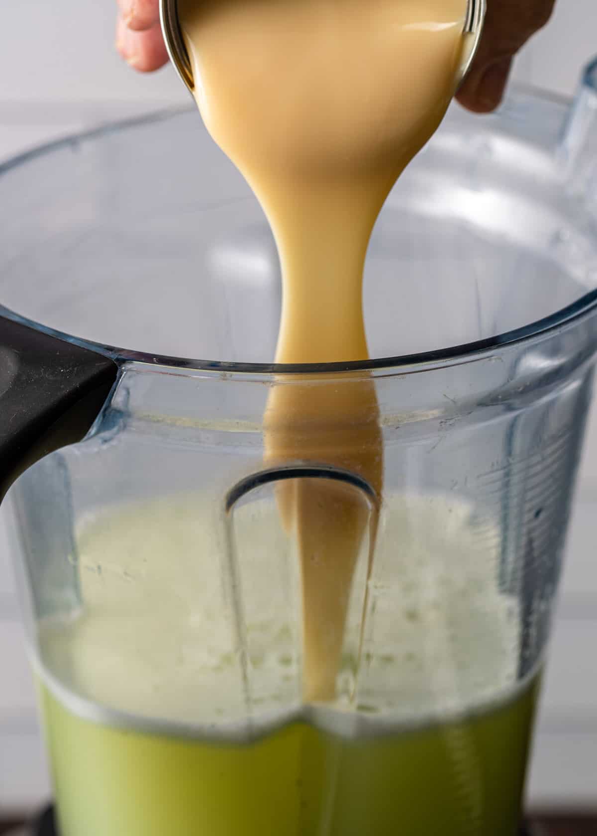 pouring coconut milk into a blender