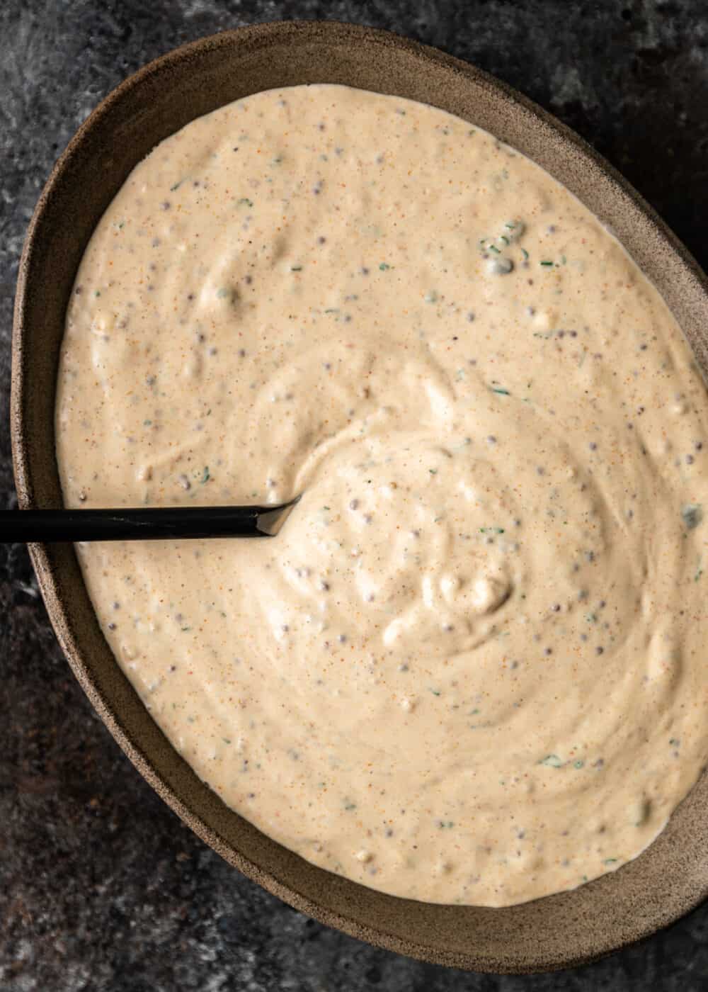 Cajun remoulade in large brown bowl with ladle