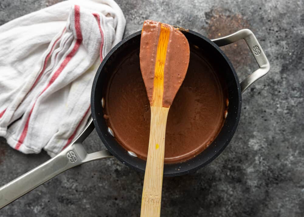 overhead: wooden spatula laid over pot of melted mexican chocolate