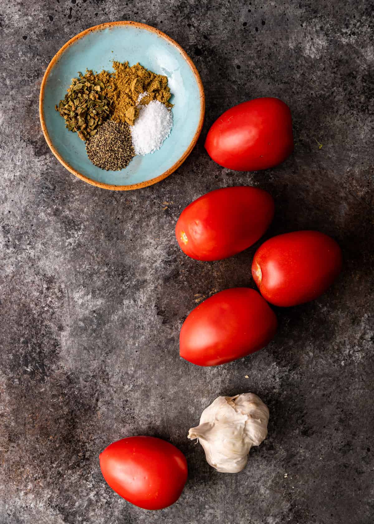 overhead: spices, tomatoes, and garlic for potato tacos