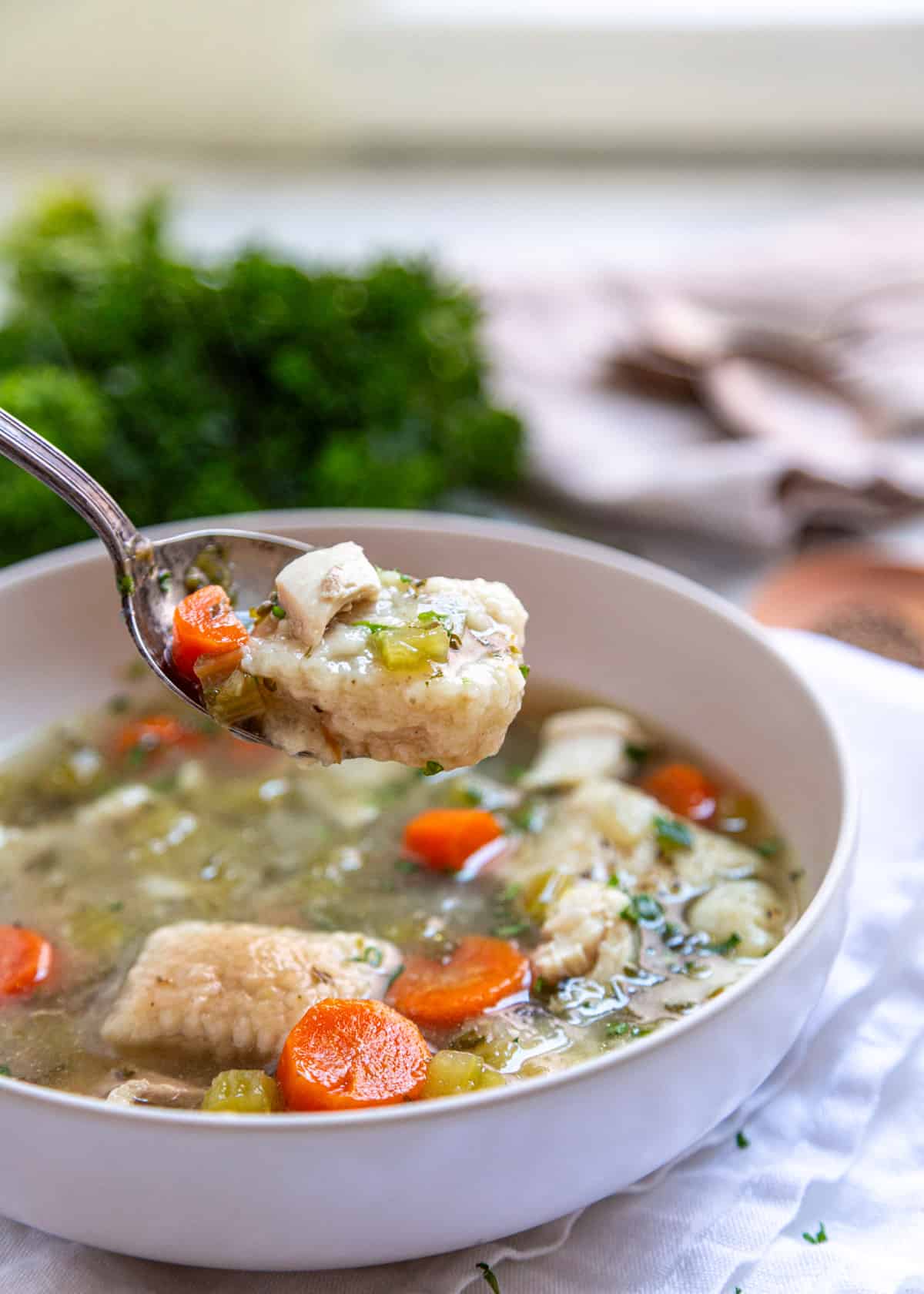 dumpling on spoon over bowl of soup