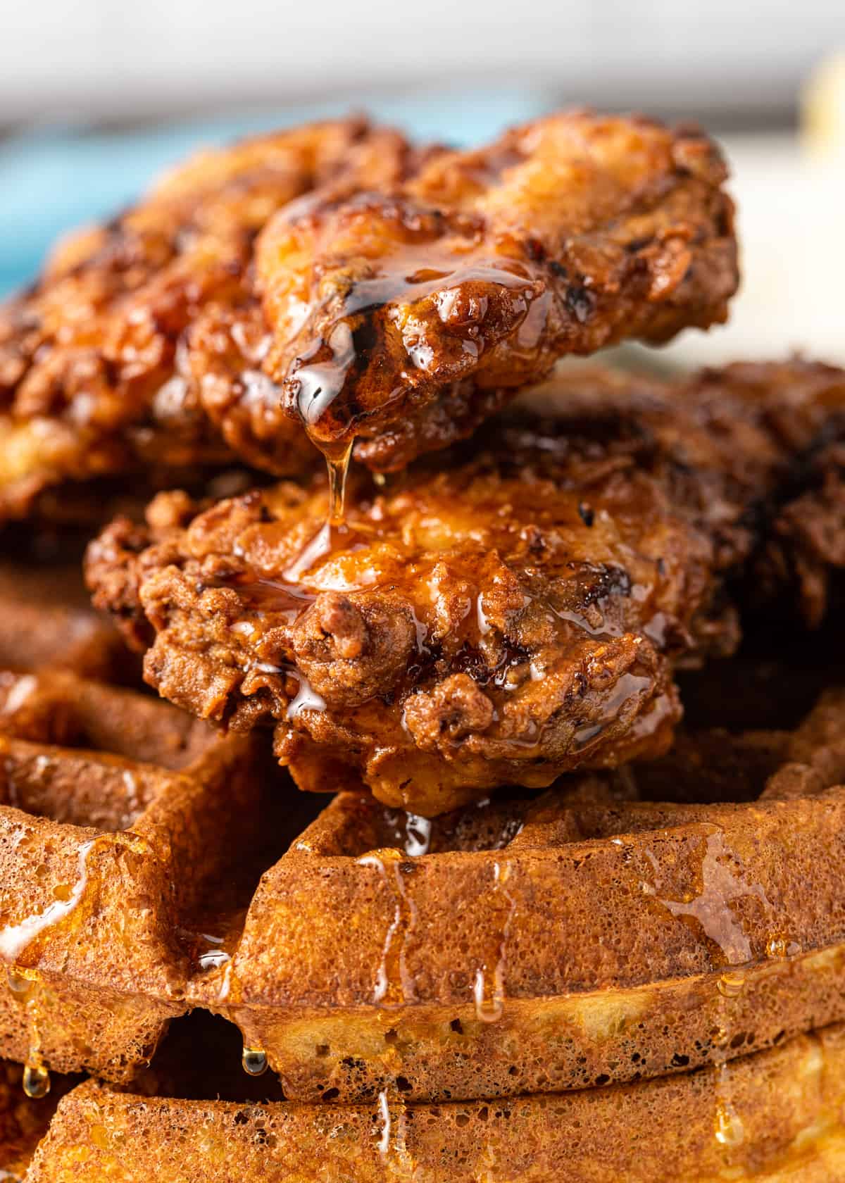 closeup of chicken and waffles drizzled in syrup