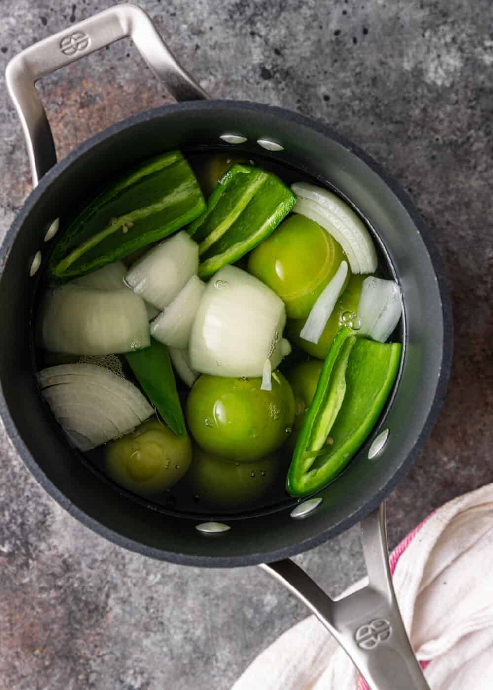 cooking vegetables and chiles in pan