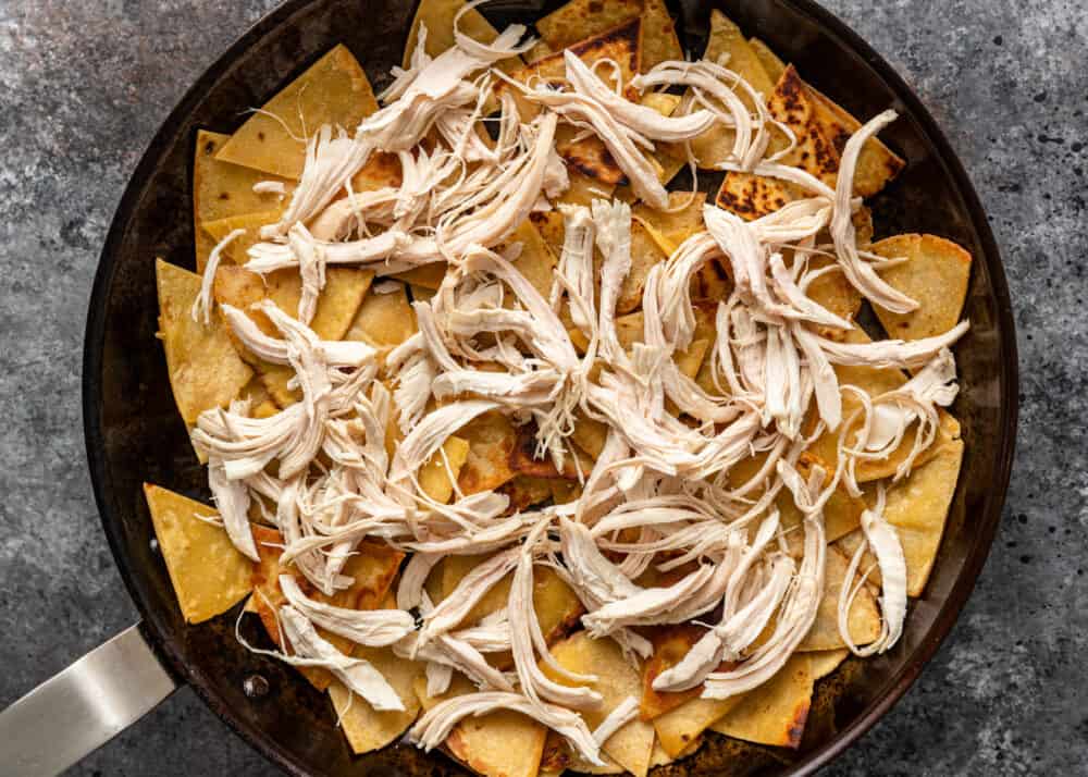 adding chicken to tortilla chips