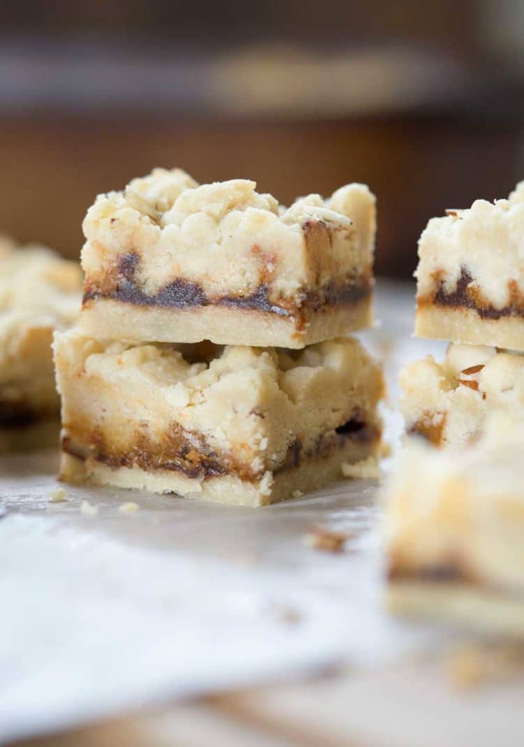 A family favorite! These Caramel Butter Bars are a buttery shortbread bar cookie with chocolate and caramel. The crumble topping with slivered almonds covers the decadent filling. So good! www.keviniscooking.com