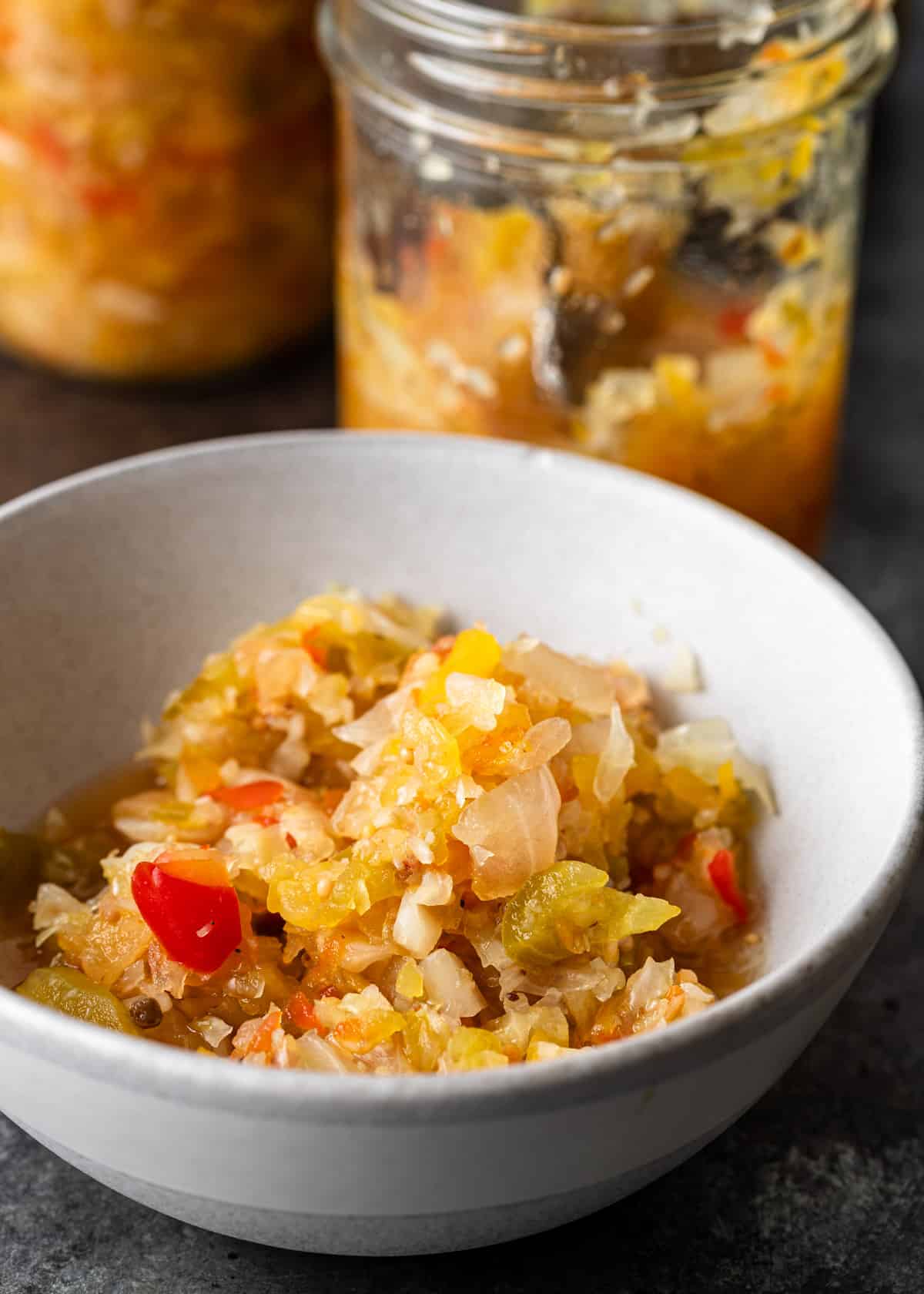 side view closeup: a bowl with Chow Chow relish and a jar with more showing