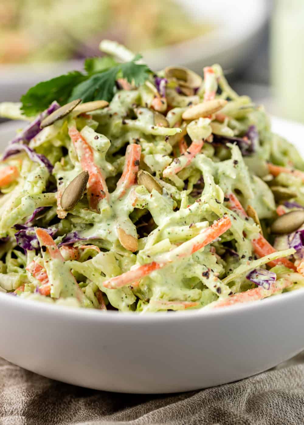 side view: close up of cilantro lime slaw in white serving bowl