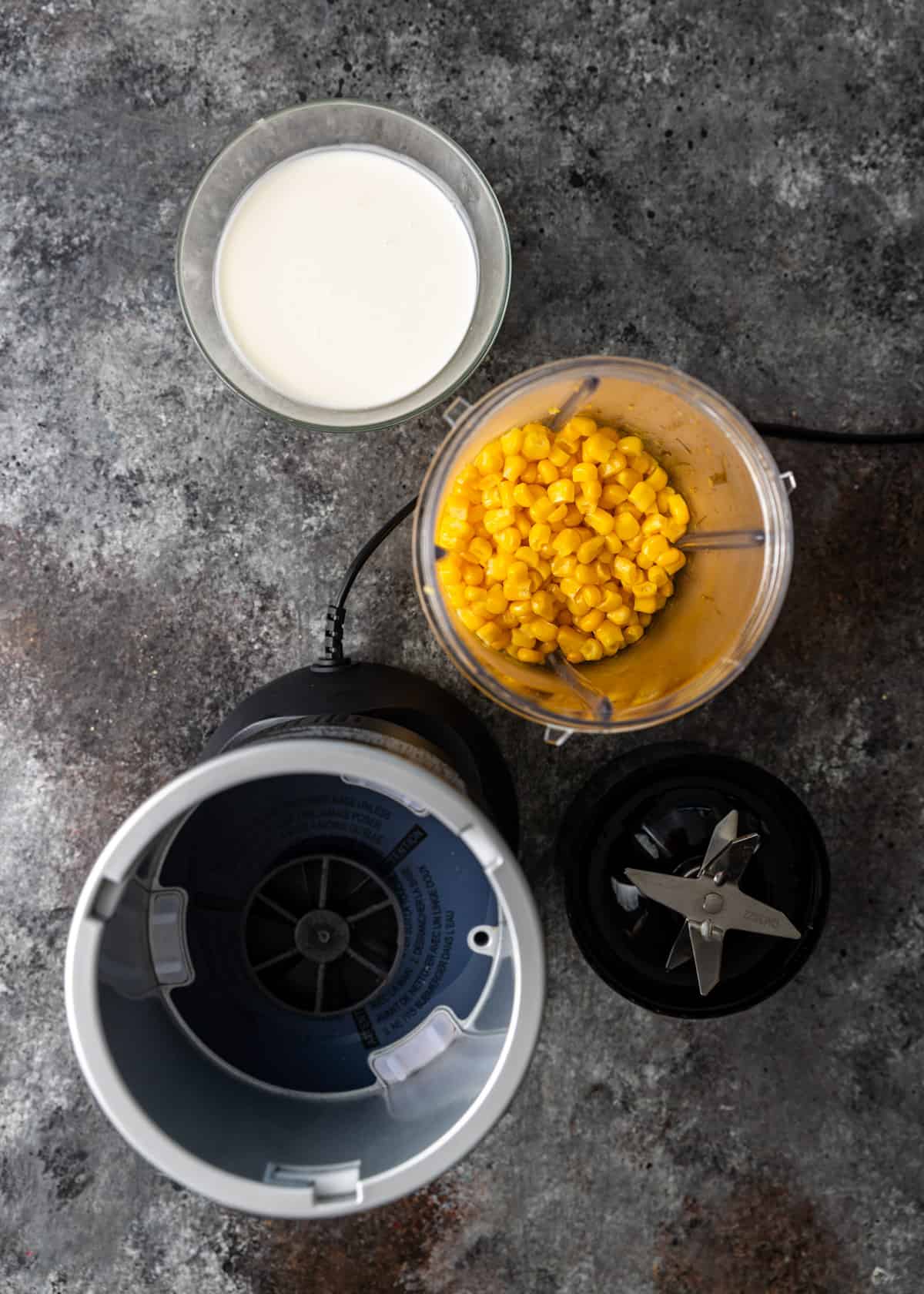 overhead: cooked corn in a blender before blending with a cup of heavy cream 
