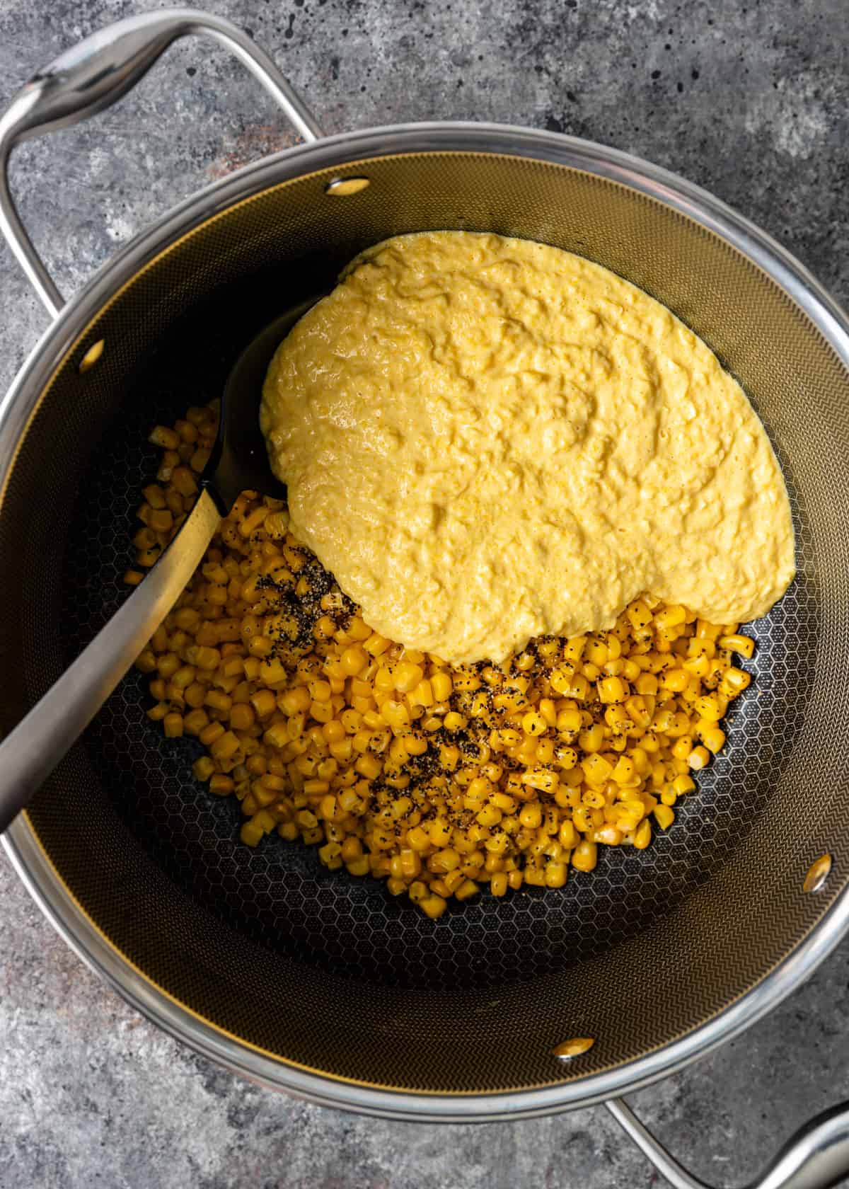 overhead: blended corn and cream mixture with to more cooked corn in a large pot