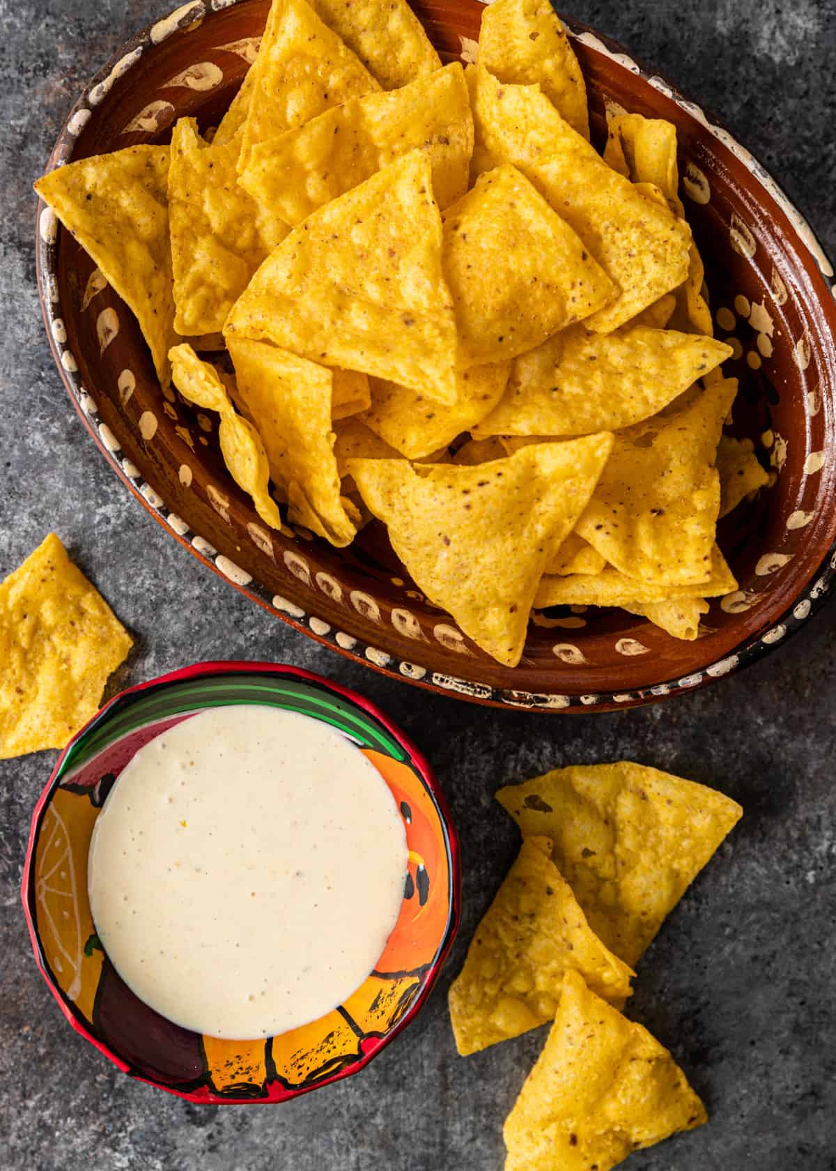 overhead: a ceramic bowl full of tortilla chips with a small bowl of creamy habanero sauce to the side