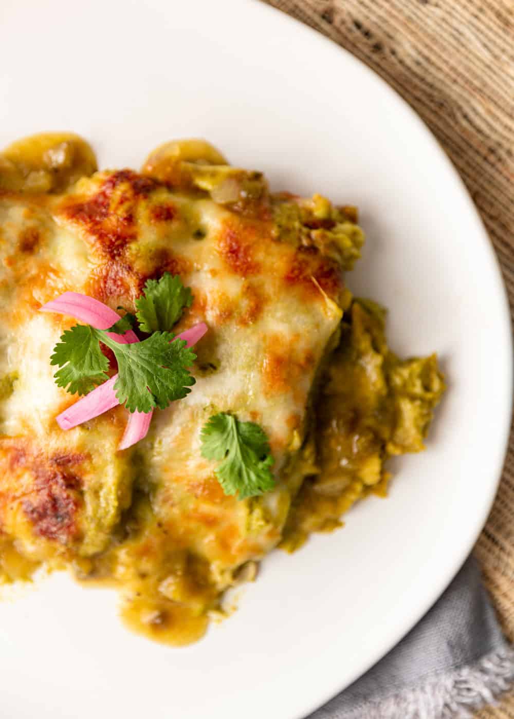 overhead: white chicken enchiladas on white plate