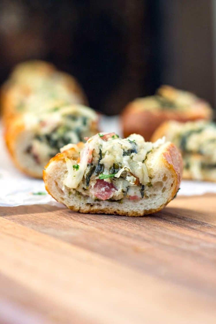 This easy, cheesy, creamy feta and spinach stuffed french bread is deliriously rich and tasty. It reminds me of a Greek spanakopita but all stuffed inside a wonderful sourdough bread loaf. Perfect hand held appetizer for parties or the holidays! www.keviniscooking.com