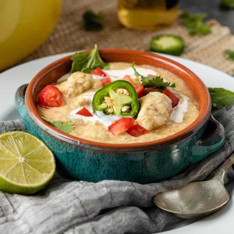 bowl of creamy chicken tortilla soup garnished with jalapeno slices and diced chicken breast