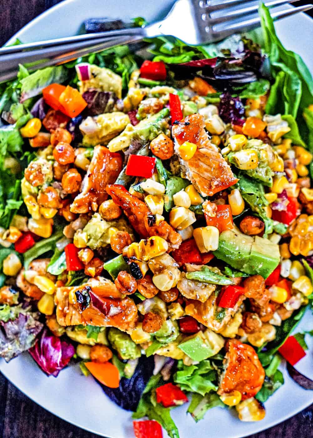 overhead: plate of salad greens with grilled corn, southwestern veggies and slices of chicken breast