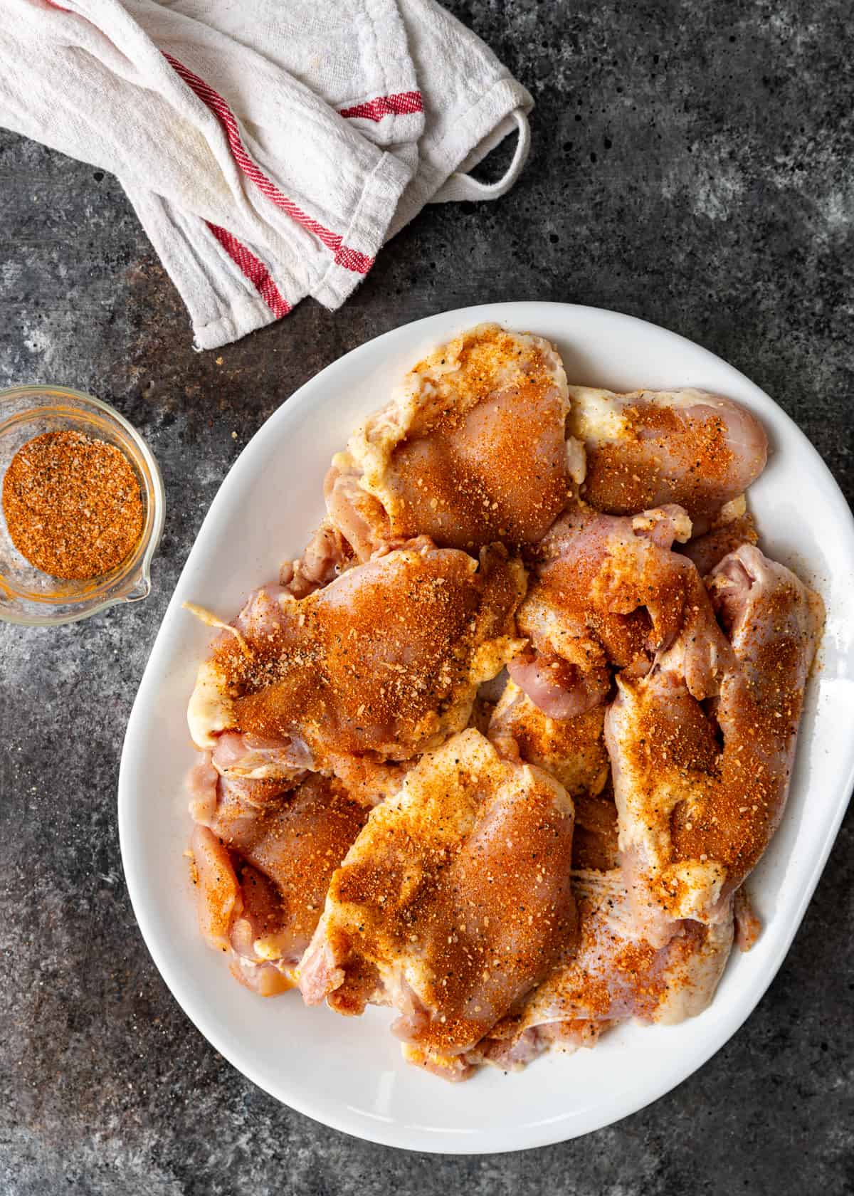 overhead: seasoning the chicken for pan seared chicken thighs