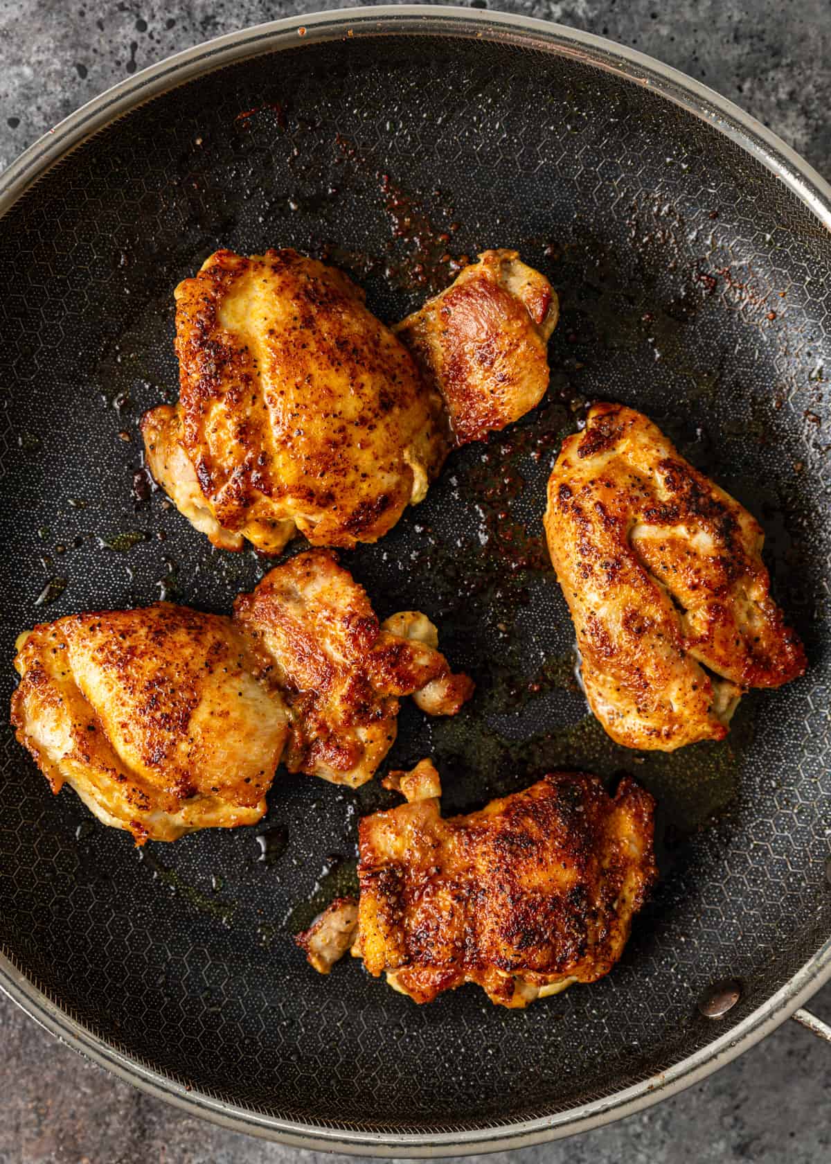 overhead: pan seared chicken thighs in a skillet