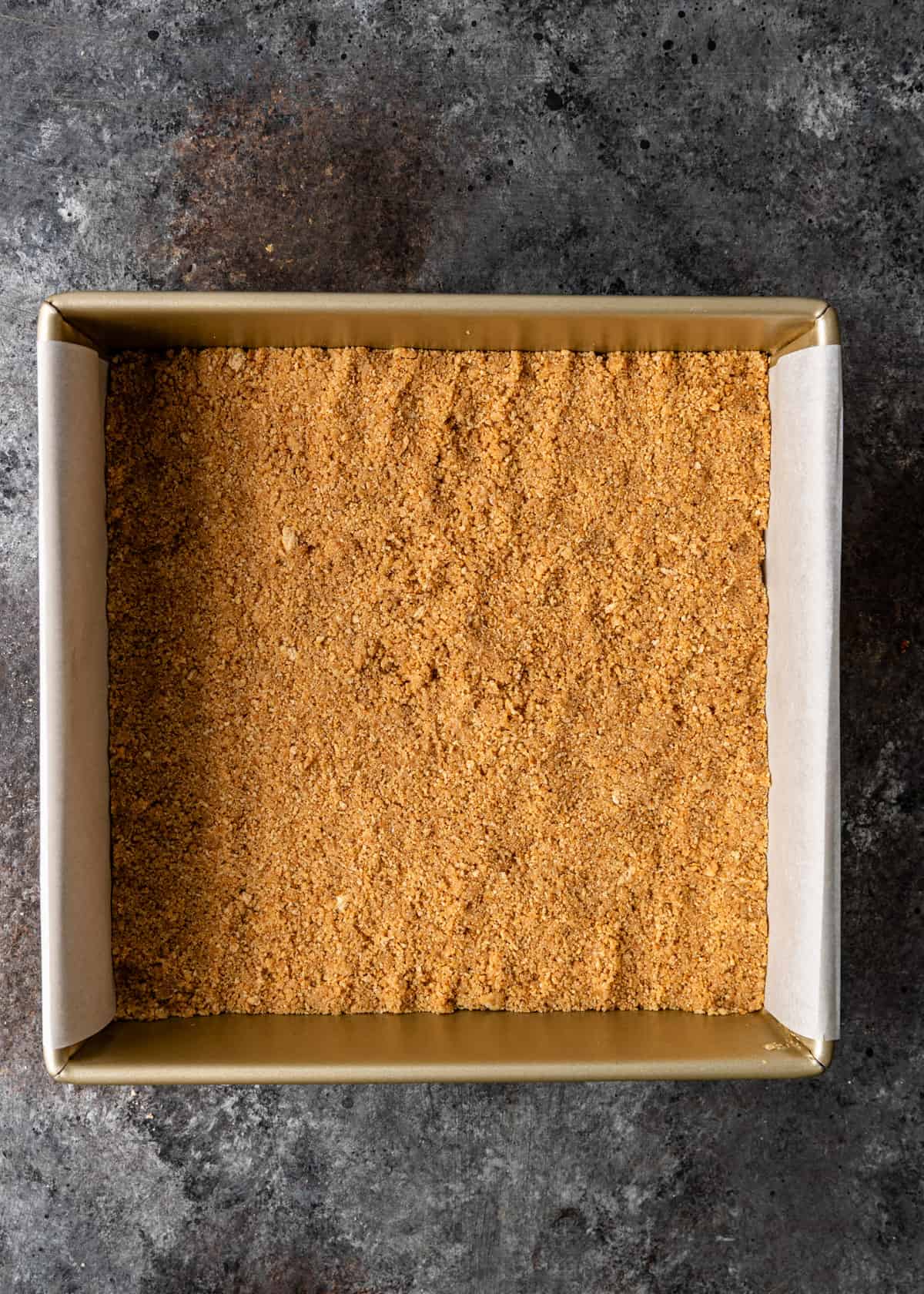 overhead: graham cracker layer flattened in baking pan