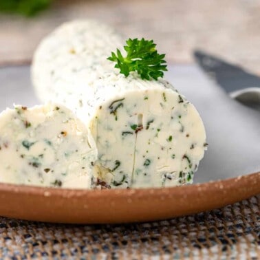 small plate of steak butter (compound butter for steak) with fresh herbs and Gorgonzola blue cheese
