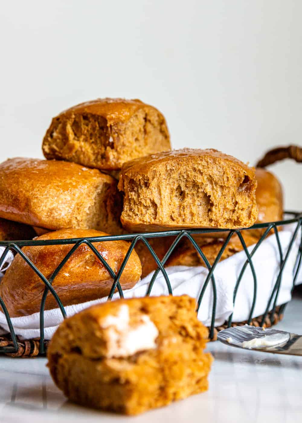 basket of freshly baked yeast rolls - one with melted butter