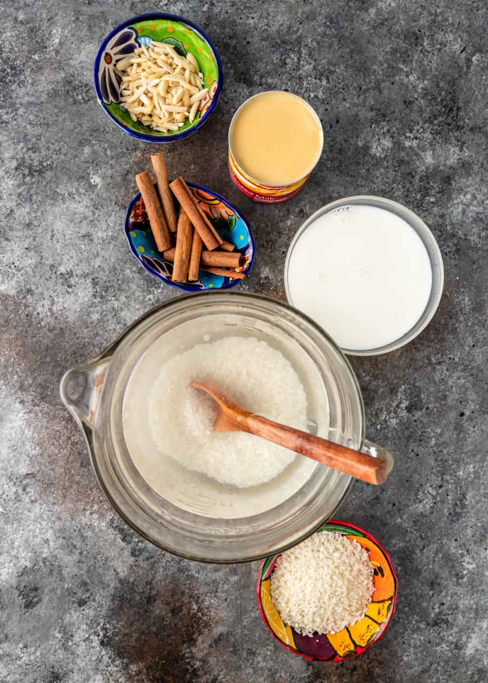 overhead: ingredients in small bowls and liquid measuring cups to make a horchata recipe