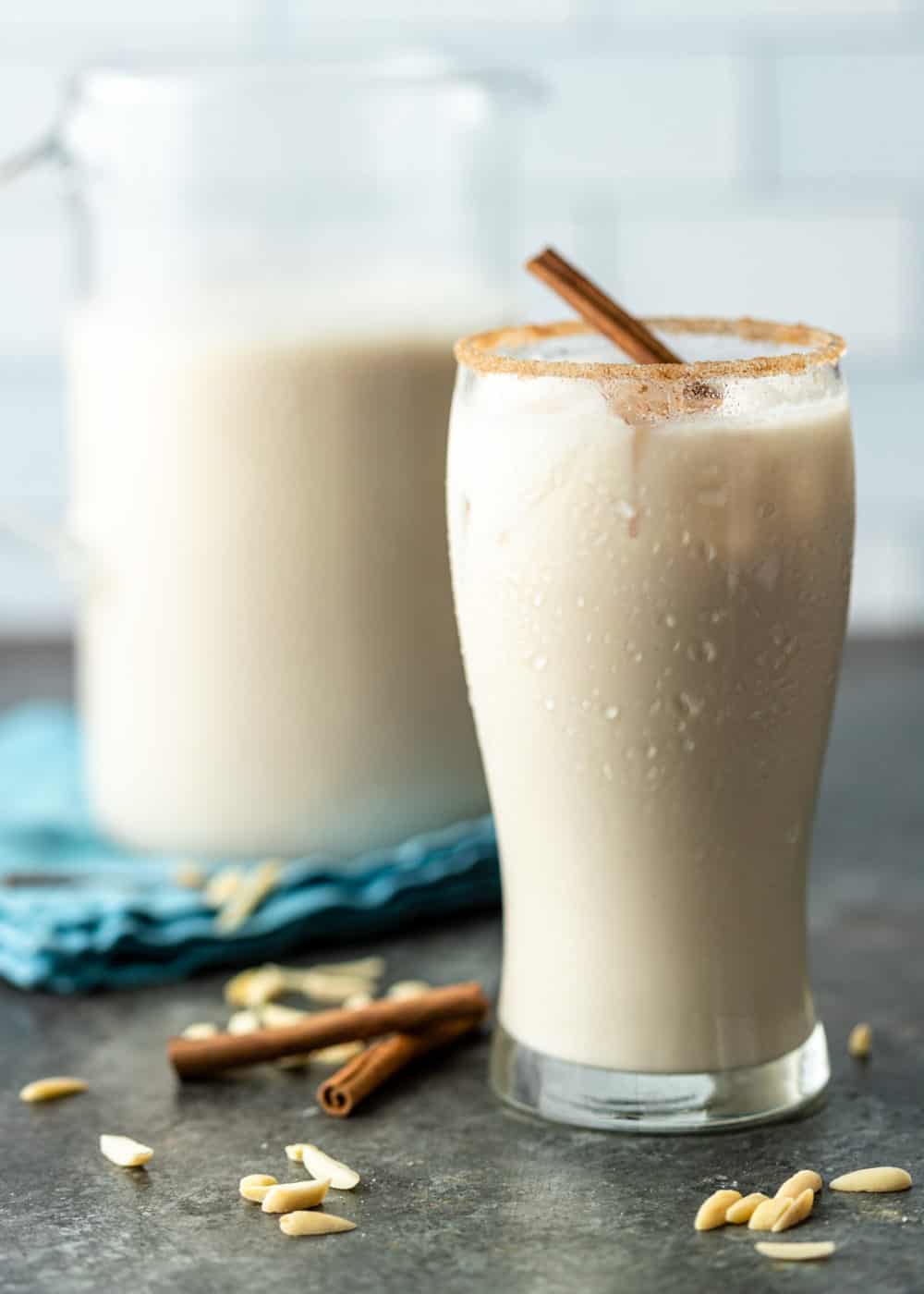 side view: creamy cold Mexican horchata drink in tall glass with condensation on the outside.