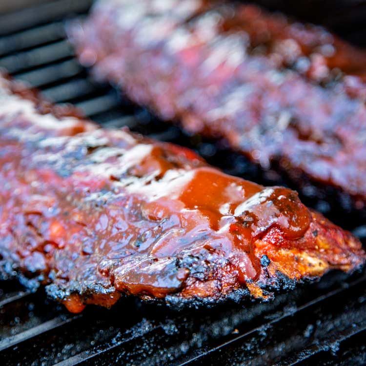 pork ribs on grill with sauce