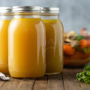 A close up of Glass jars of chicken broth