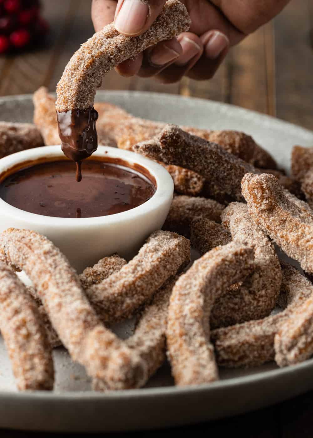 churro being dipped into chocolate sauce