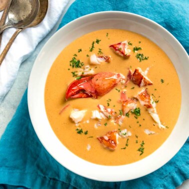 overhead image: lobster bisque in white bowl on blue linen napkin