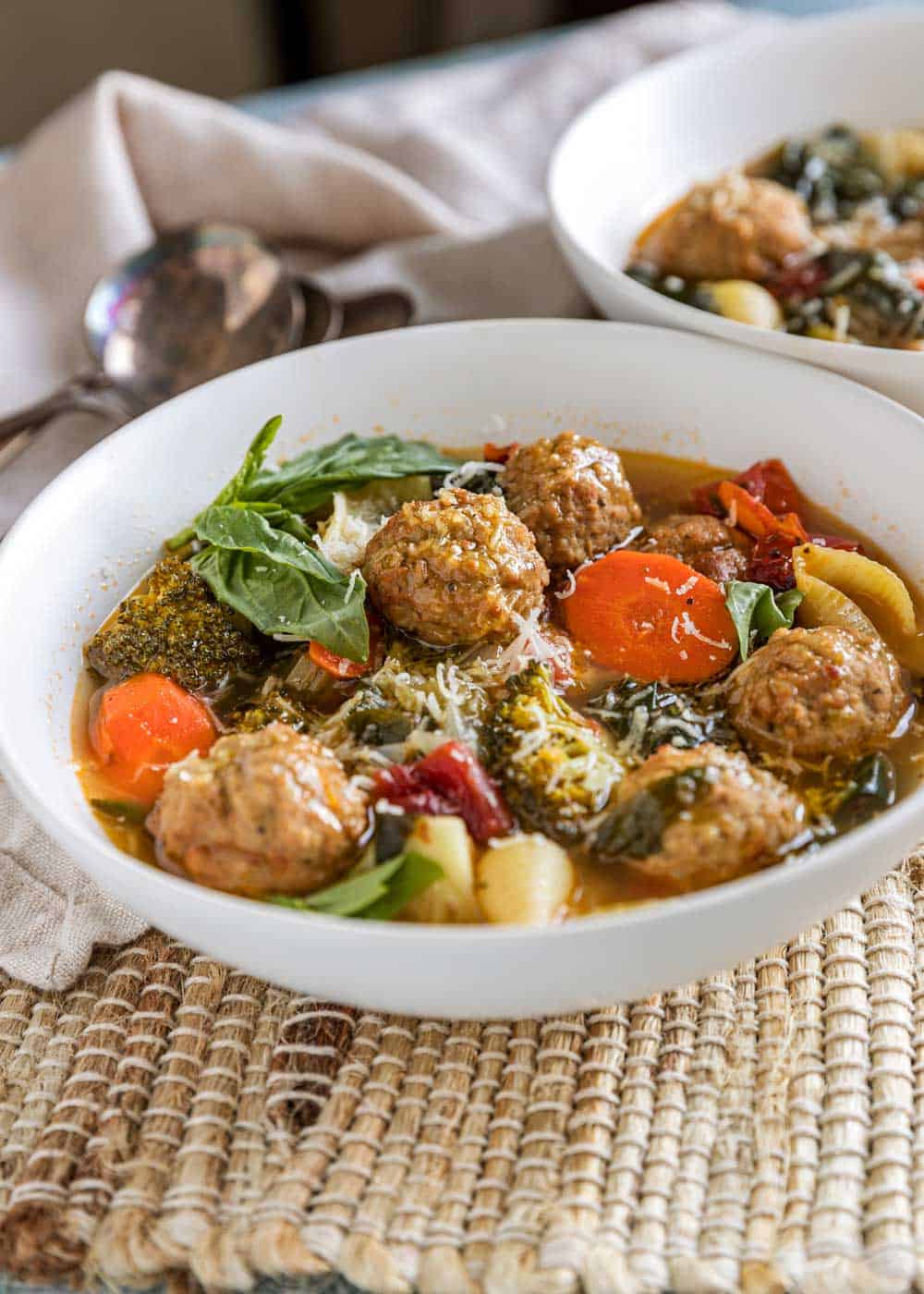 bowl of meatball soup in white bowl on place mat