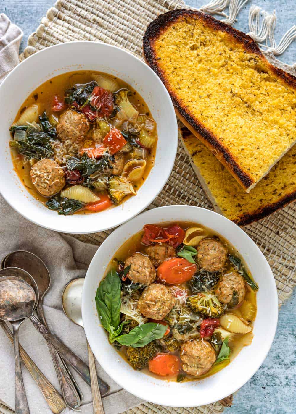 overhead shot of 2 bowls of italian meatball soup and garlic bread