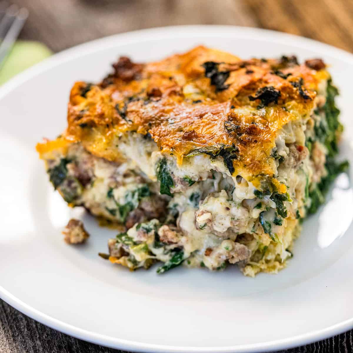 closeup: serving of baked eggs casserole on white plate