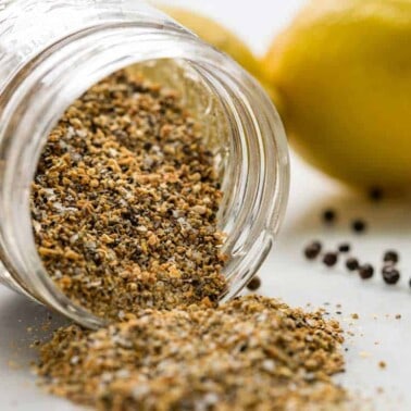 close up of Lemon Pepper Seasoning tipped over in glass jar