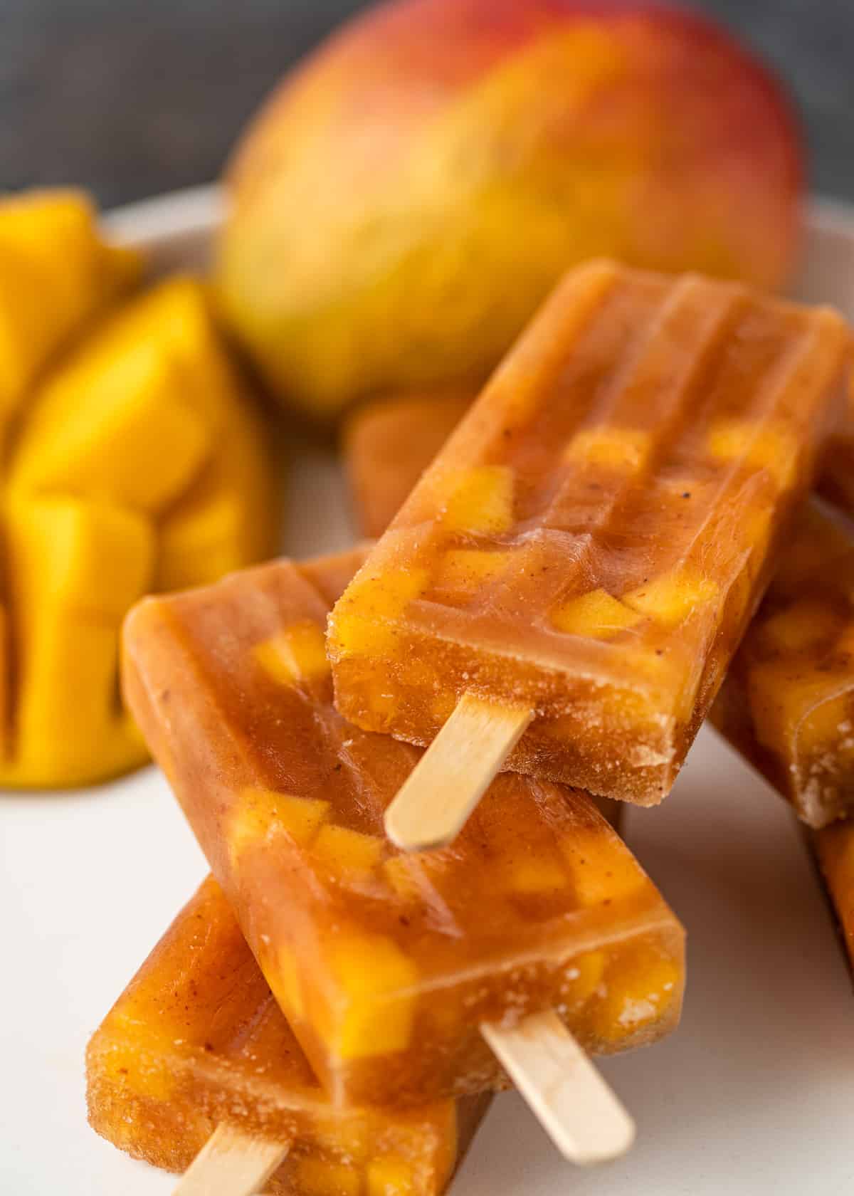 close up of a white plate full of mango paletas