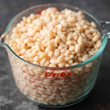 preparing to quick soak beans in glass measuring cup