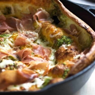 close up of a pesto prosciutto dutch baby in skillet