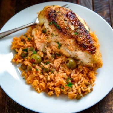 Puerto Rican Chicken and Rice is a Latin classic and packed with flavor, not heat. Browned chicken simmers in rice, flavorful sofrito, olives and capers. keviniscookingcom