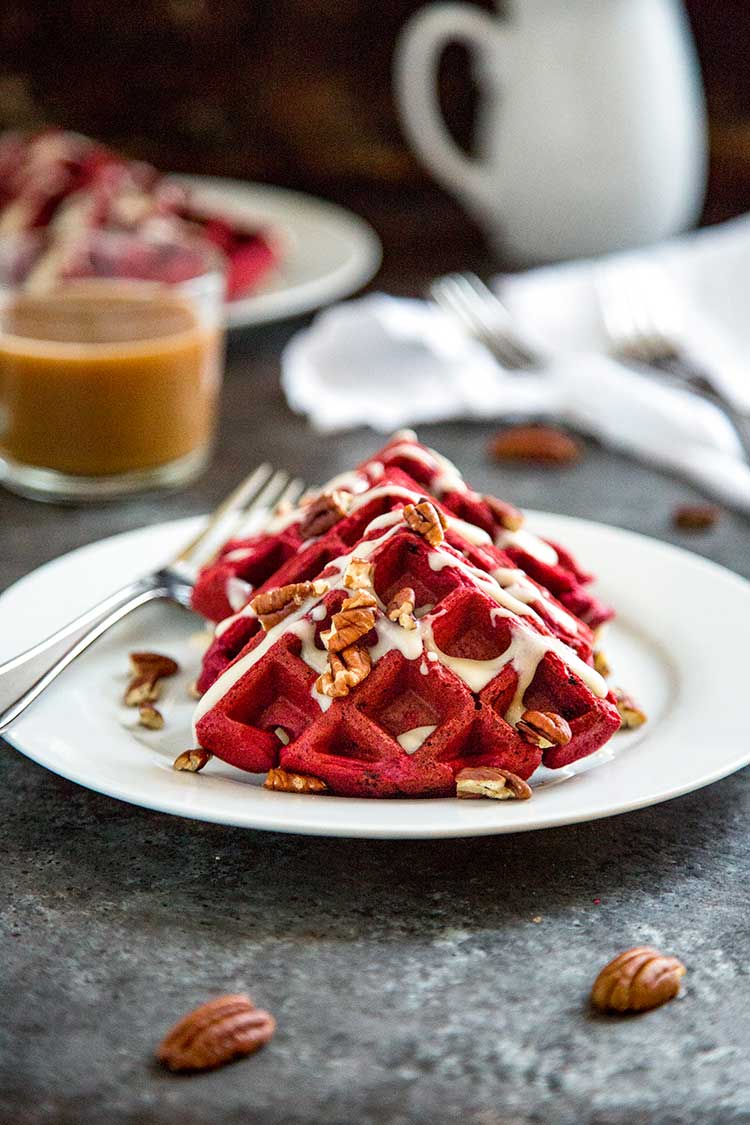 Red Velvet Waffles with Cream Cheese Glaze on white plate viewing front of waffles.