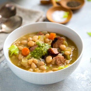 This Slow Cooker White Bean Soup has added beef kielbasa sausage for a heartier meal. Grilled or pan seared for that added caramelization flavor, plus a touch of fresh pesto tops it all before serving. www.keviniscooking.com