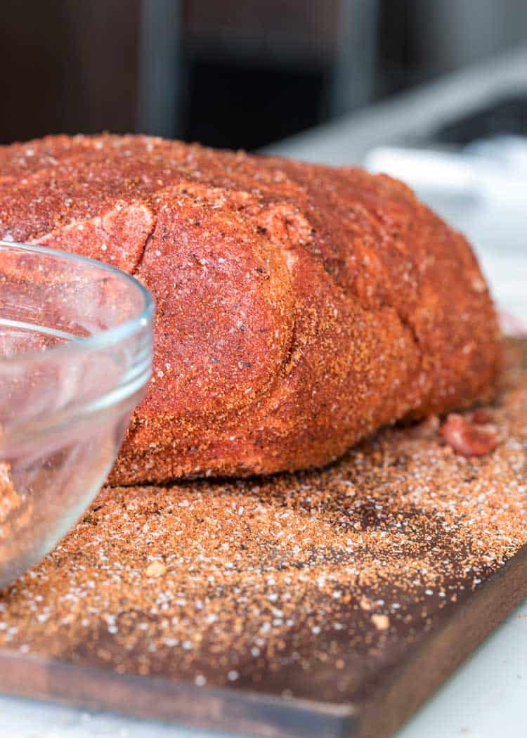 dry rubbed pork shoulder on wood cutting board